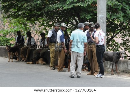 KANDY, SRI LANKA - DECEMBER 5, 2008: Police dog handlers with dogs on the streets of Kandy. Kandy is a city in the Central part of Sri Lanka. Known as one of the sacred Buddhist cities.