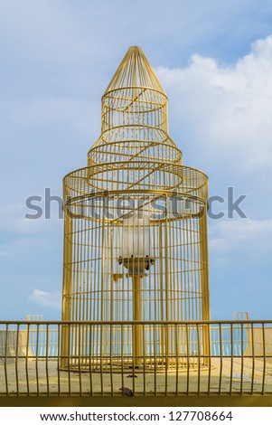 A light bulb is covered by a golden cage