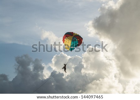 people playing a parachute with cloudy blue sky