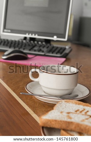 coffee and bread for breakfast on office desk