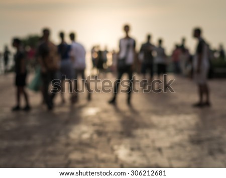 Blurred group of people during sunset with cloudy sky background