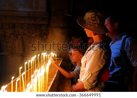 Jerusalem, Israel - May 8, 2013: Pilgrims, tourists light candles at the tomb of the Lord and pray.
