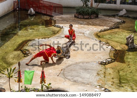 THAILAND, SAMUT PRAKAN - DECEMBER 31: An unidentified zoo keeper puts a head in a mouth of the crocodile as part of 