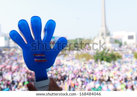 Blue hand as Thai people against government and victory monument background