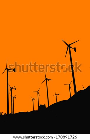 Silhouette of wind turbines in farm