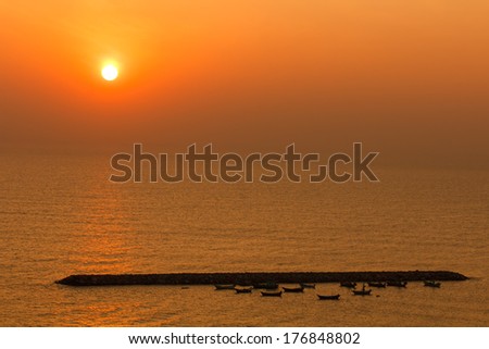 Reflection of sunlight on the water at sunrise and small boat view, Thailand