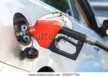 Red pumping fuel oil in car at gas station-2