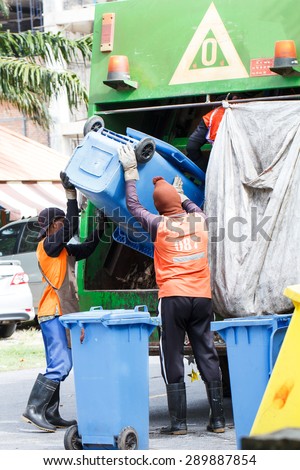 Two urban workers municipal recycling garbage collector truck loading waste and trash bin