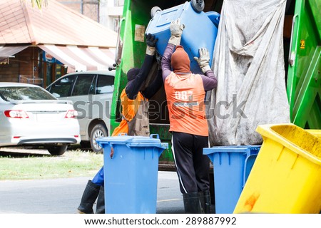 Two urban workers municipal recycling garbage collector truck loading waste and trash bin