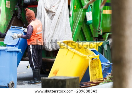 Urban worker municipal recycling garbage collector truck loading waste and trash bin
