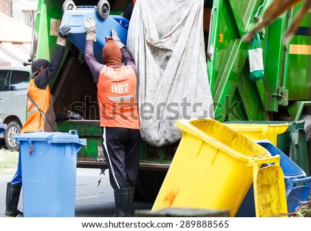 Urban worker municipal recycling garbage collector truck loading waste and trash bin