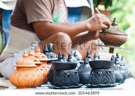 Pottery souvenir with craftspeople working background
