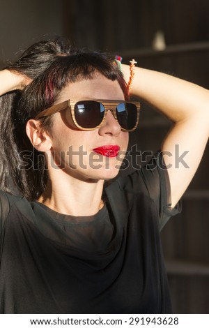 Beautiful young model wearing handmade wooden sunglasses.