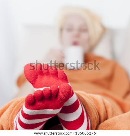 sleepy women lying on sofa drinking hot beverage