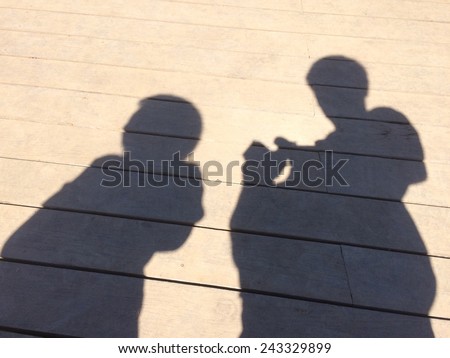 Shadow of man and woman on wood floor, man trying to talk with woman when women was upset.