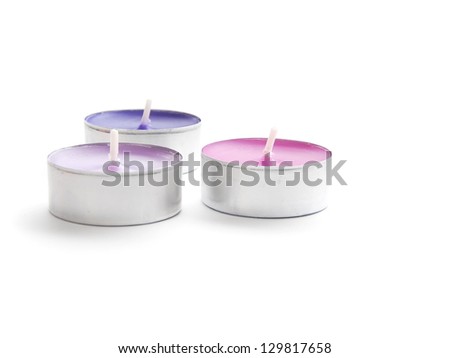 Three scented candles not lit on a white background
