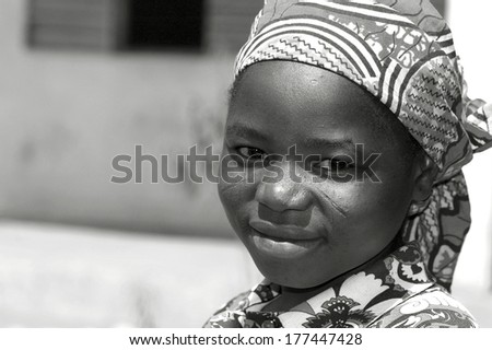 CIRCA 2009 Cameroon, Gayak. Portrait of an african young girl smiling, her head covered with colourful green and red pattern african traditional cloth.