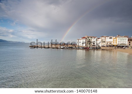 Cloudy and blue sky at a mediterranean sea town/ The rainbow over a little fisherman town
