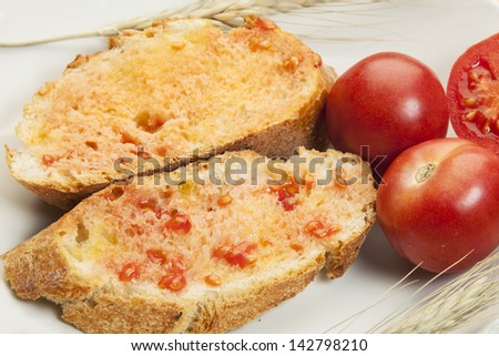 Peasant bread  with tomato rubbed over and seasoned with olive oil and salt/ Mediterranean diet. Bread with tomato and olive oil