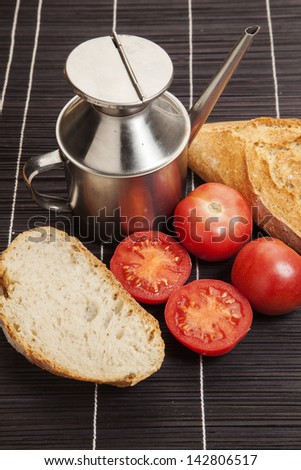 Fresh baked wheat bread, tomatoes and an old metal cruet/ Fresh baked wheat bread, tomatoes and an old metal cruet.