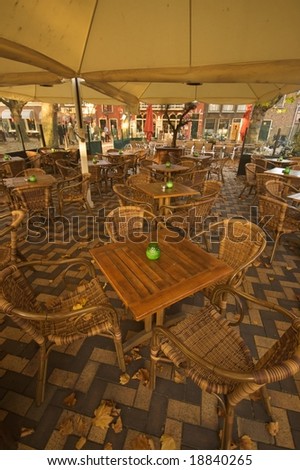 Open air cafeteria with wooden tables and rattan chairs