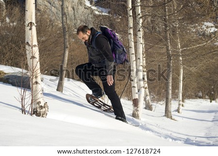 Man in snow shoes in a winter forest