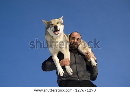 Man playing with Czechoslovakian wolf dog