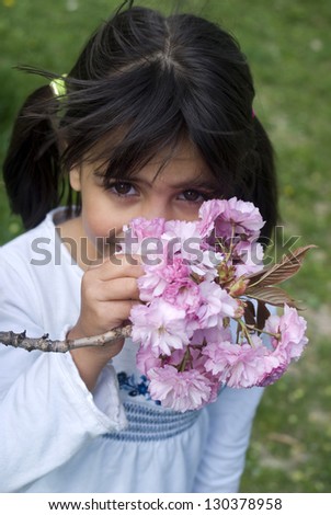 Girl smelling pink flowers of fruit tree