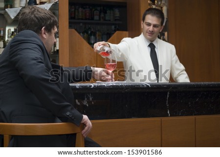 Barman serving drink a man