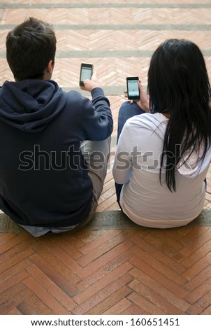 Young couple looking at cell phones