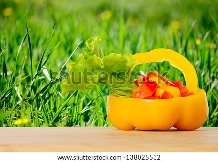 Bell pepper on a bamboo board on the green grass background