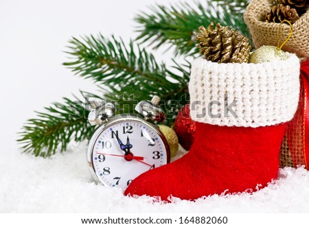 Santa\'s boot  with gifts and clock on snow
