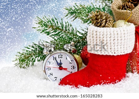 Santa\'s boot  with gifts and clock on snow