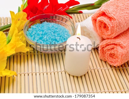 Spa still life with sea salt, burning candle and terry towels