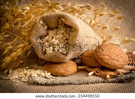 Oat flakes in the bag, oat cookies and spikelets on sackcloth