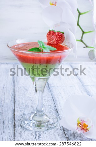 Fresh fruit and berry cocktail with strawberries, kiwi and mint leaf on whiteÂ background