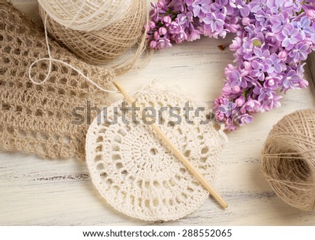 Yarn for crochet and knitted openwork napkins with lilac on shabby wooden board