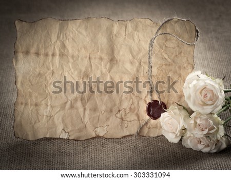 Ancient parchment with red wax seal and roses on sackcloth. For this photo applied vignetting effect in retro style.