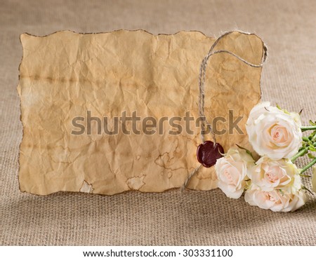 Ancient parchment with red wax seal and roses on sackcloth