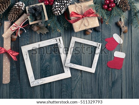 Christmas background with photo frame, spruce, gift box, Santa Claus boots and scroll in vintage style on wooden shabby boards. Top view.