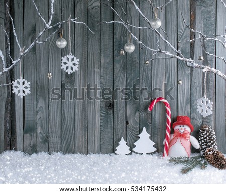 Christmas interior with decorative branches, snowman and candy cane on wooden planks background. New Year winter composition.