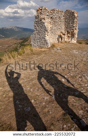 Two funny people\'s shadows in a ashes of ancient Castle