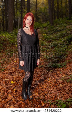 Pretty woman with red hair portrait  in gothic dress in the fall season