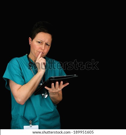 thinking vet/nurse/health care worker using tablet. Isolated portrait on black background with copy space.