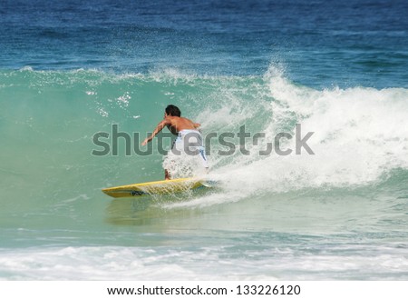 Young guy surfing the wave in Brasil