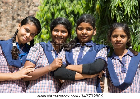 DELHI, INDIA - OCTOBER 11, 2015: unidentified local school girls for tour in Qutub Minar complex, Delhi, India, as part of national education. The girls in school uniform have fun posing for a foto.