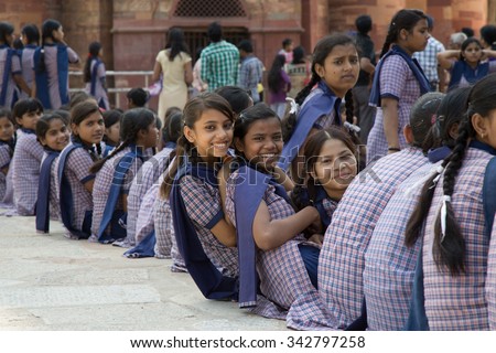 DELHI, INDIA - OCTOBER 11, 2015: unidentified local school girls for tour in Qutub Minar complex, Delhi, India, as part of national education. The girls in school uniform have fun posing for a photo.