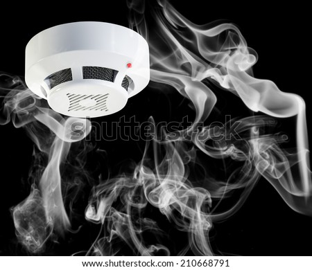 Smoke around fire detector on black background.