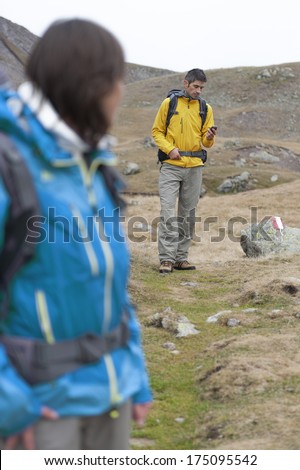 The man looks where the hiking trail runs