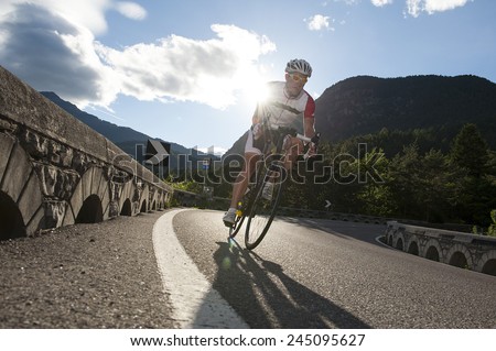 road cycling in the mountains with sunrise behind